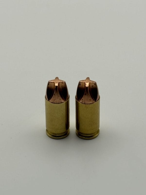 ms Ammunition – High-Quality Ammunition for Rifles and Shotguns" Alt Text: Two high-quality ammo cartridges from a 380 Auto 68 Grain Xtreme Defense 20 Count Box, featuring a brass-colored metallic finish and pointed tips, are standing upright on a neutral background. The rifle cartridges reflect the meticulous craftsmanship associated with premium ammunition. While these particular examples are not shotgun shells, they exemplify the precision and reliability expected from bulk ammunition suppliers. The lighting effectively highlights their details for closer examination. Bulk Ammo Available for Purchase"