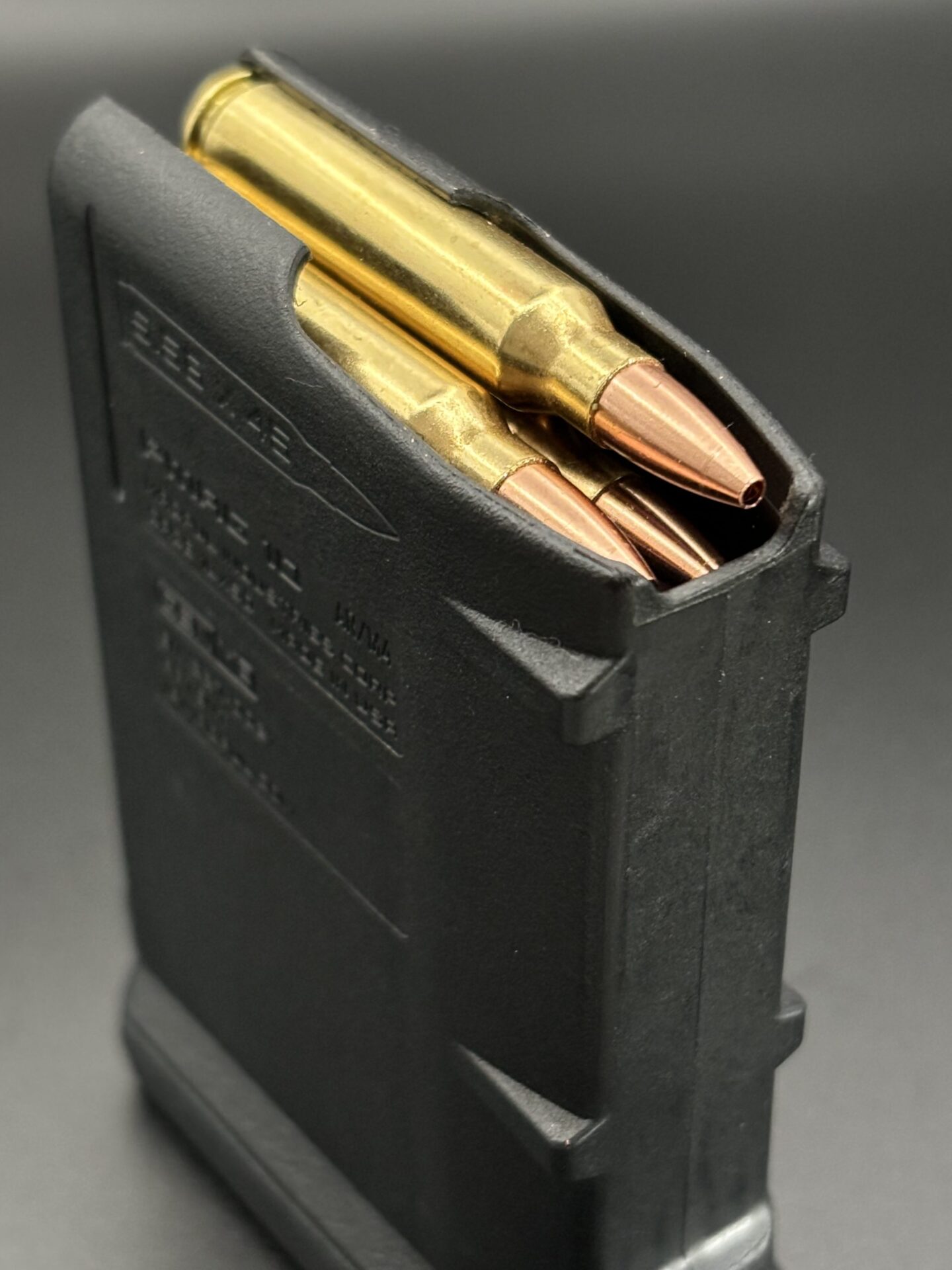 ms Ammunition – High-Quality Ammunition for Rifles and Shotguns" A black rifle magazine partially filled with several brass-colored rifle cartridges, showcasing high-quality ammo against a dark background. This image highlights the variety of ammunition options available, such as shotgun shells and bulk ammunition. Bulk Ammo Available for Purchase"